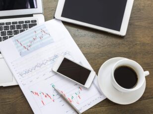 Laptop, tablet , smartphone and coffee cup with financial docume